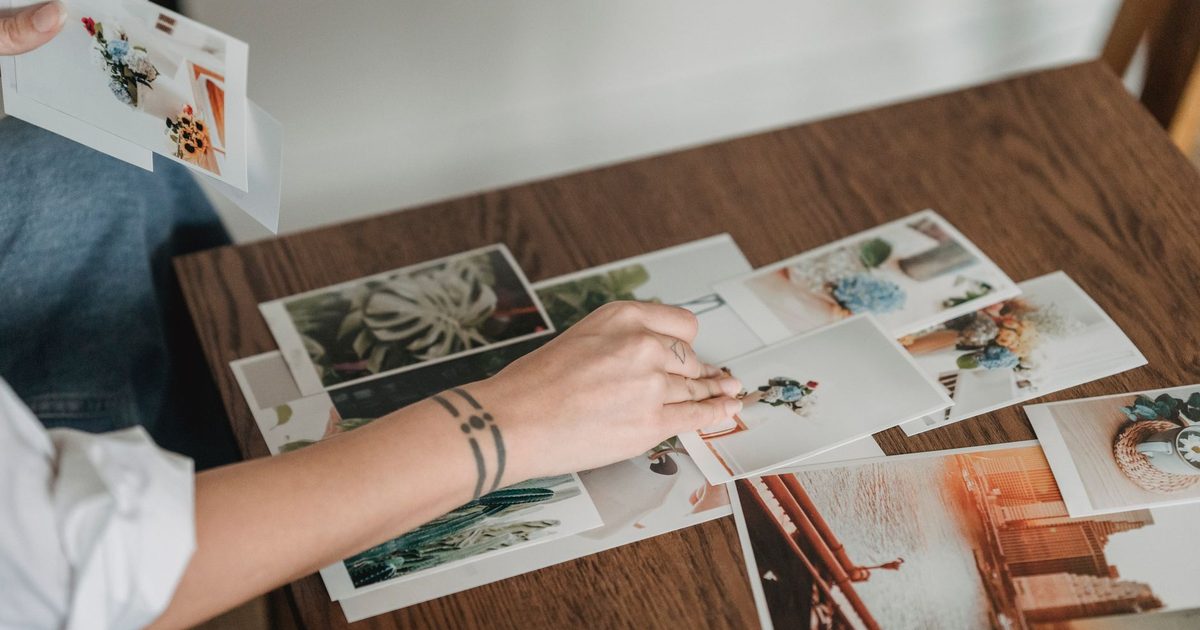 Main choisissant un tirage parmi plusieurs étalés sur une table en bois