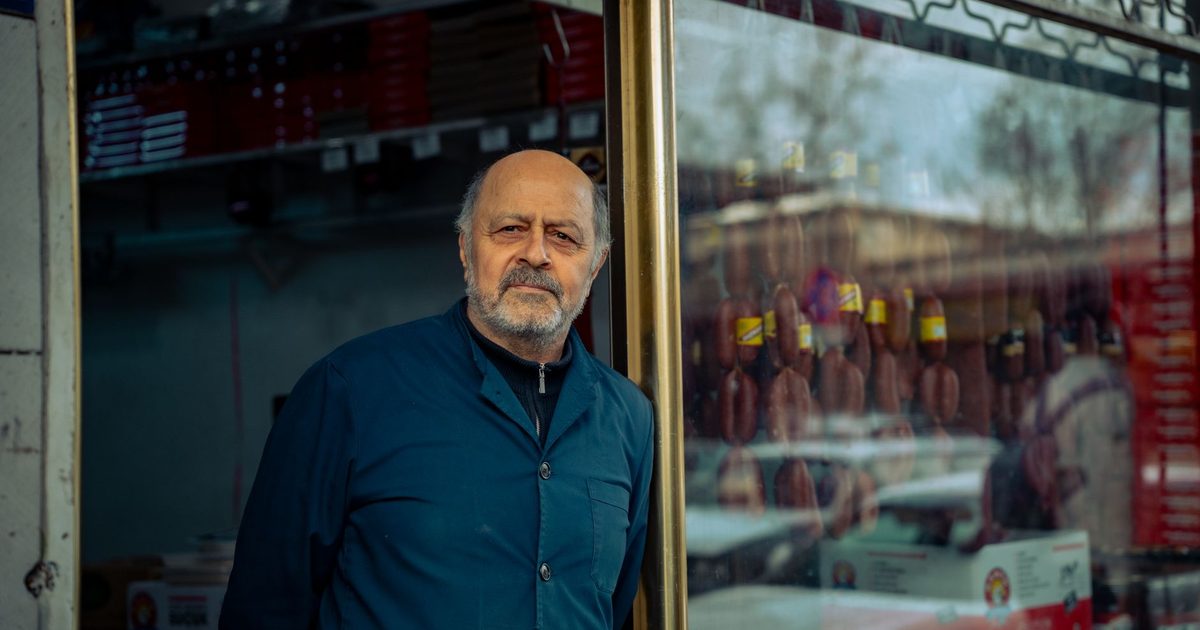 Commerçant âgé debout sur le seuil de sa propre boutique
